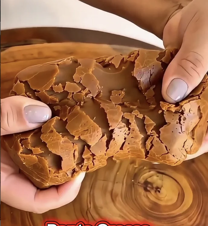 Doce de leite puxa-puxa sendo esticado, mostrando a textura macia e elástica